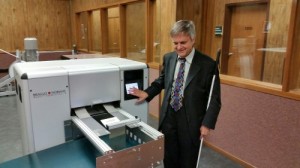Steve Booth standing next to copy machine at his office